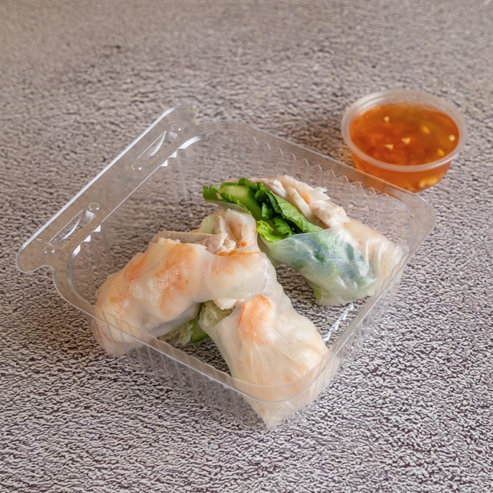 Fresh shrimp spring rolls with a side of dipping sauce.
